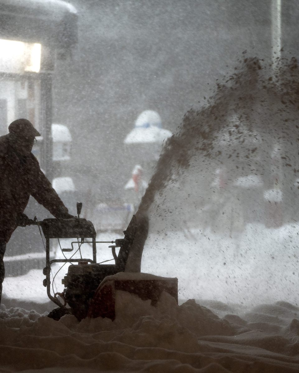 Un homme déblaie la neige dans une station-service
