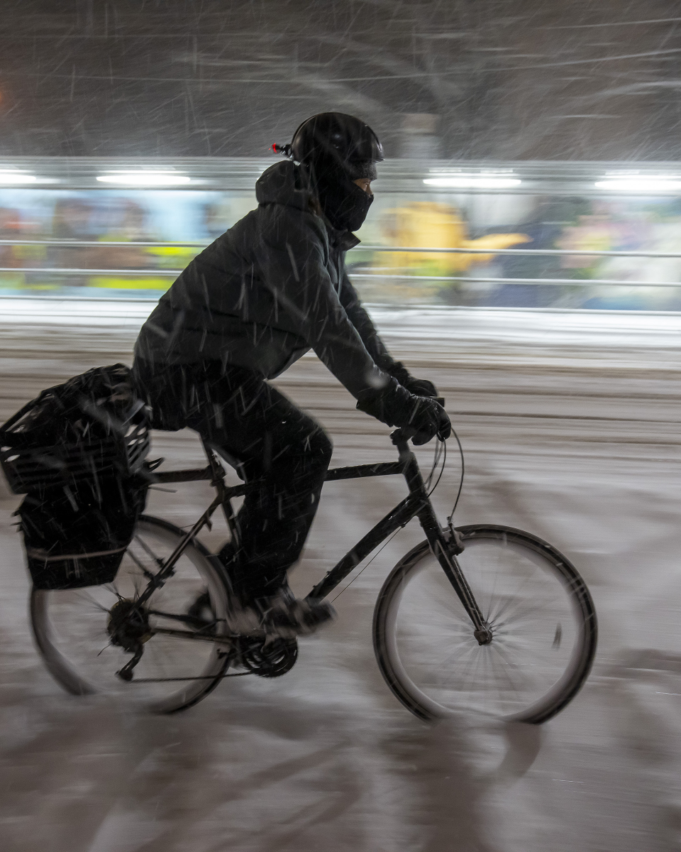 Un cycliste traverse une tempête hivernale